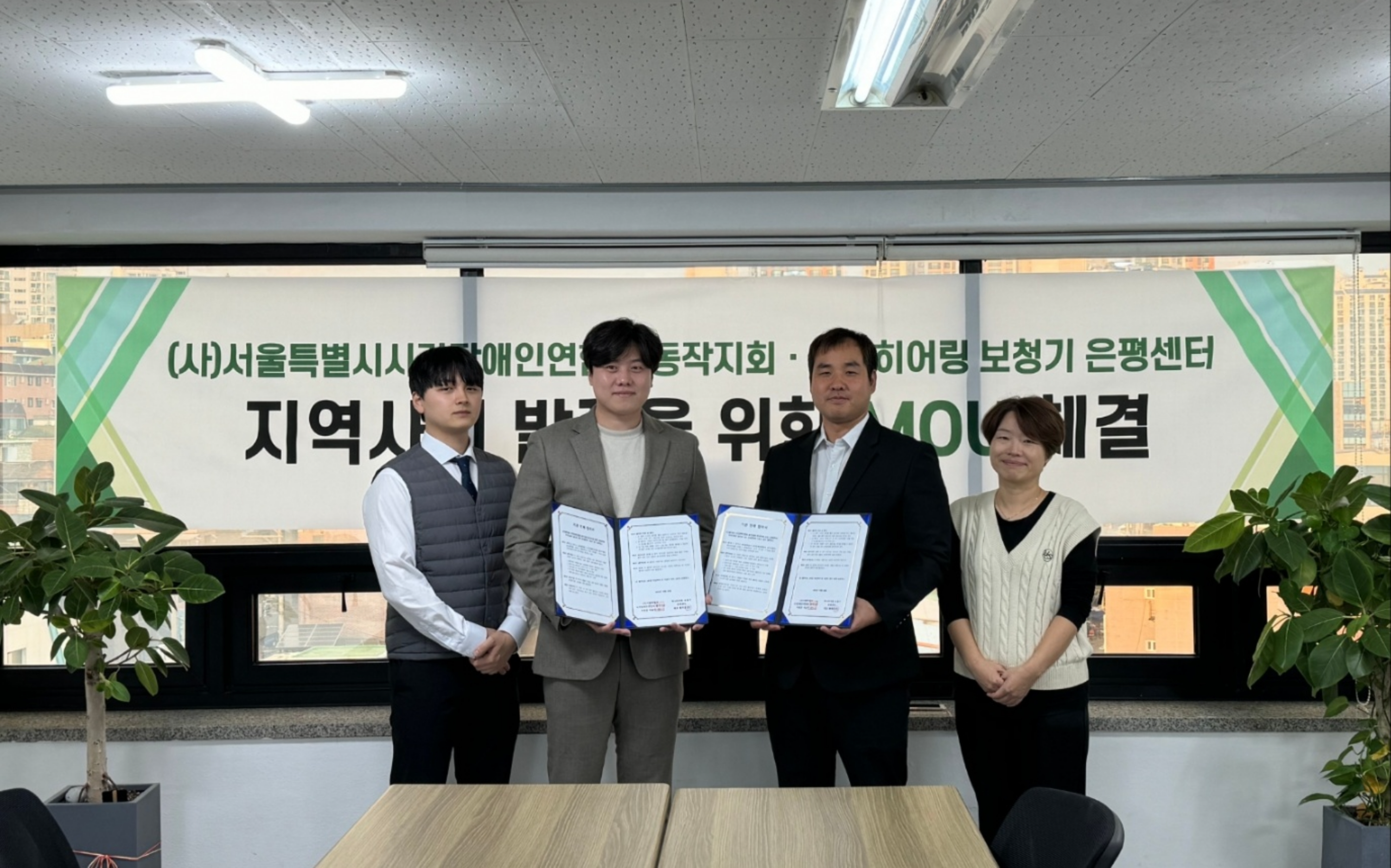 이미지설명: 왼쪽부터 하나히어링 보청기 은평센터 문석현 원장, 황영훈대표, 이승민 동작지회장, 박수진 사무국장이 기관연계협약서를 들고 함께 사진을 찍고 있다.