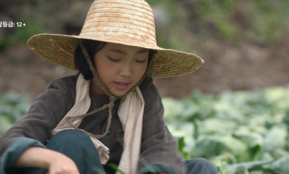 텃밭에서 앉아있는 어린이