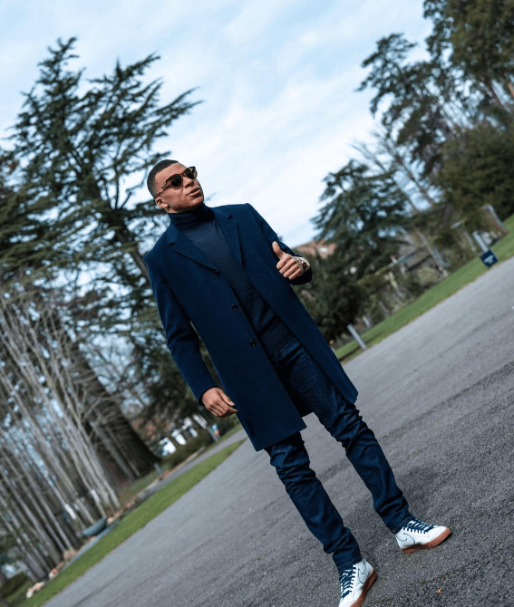 검은 코트와 검은 바지에 흰 운동화를 신은 음바페