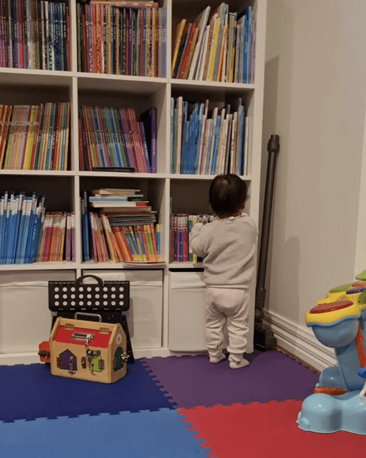 책장에서 읽고 싶은 책을 고르고 있는 아이