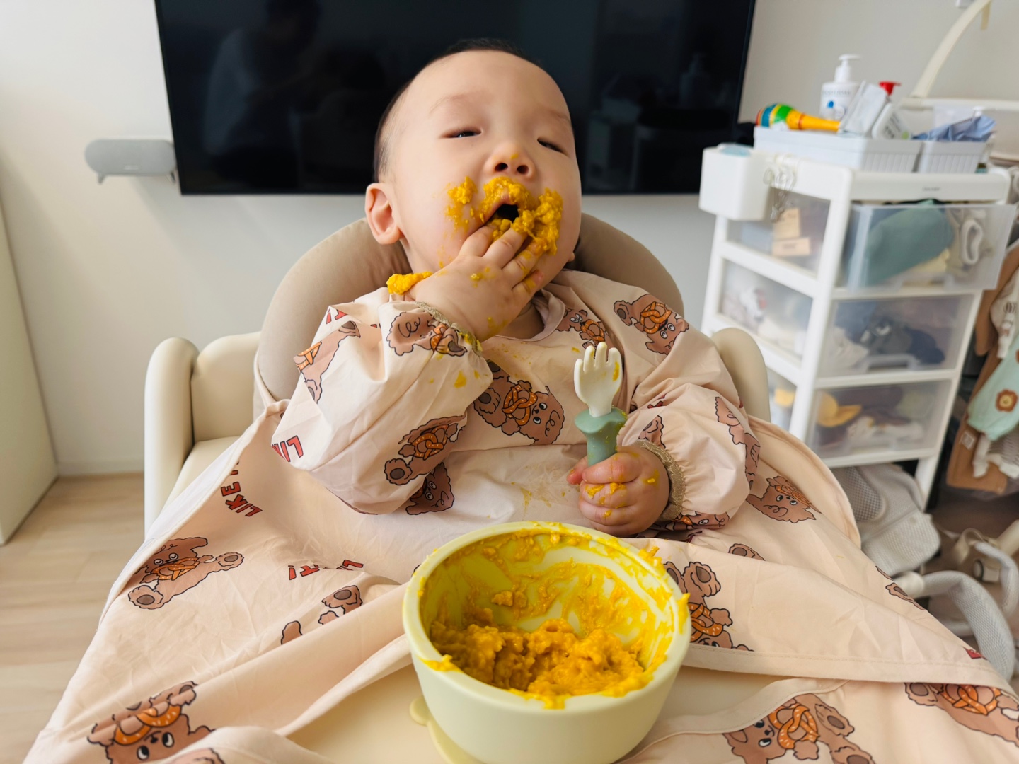 손에 단호박 포리지를 가득 묻히고 먹는 찬솔이의 자기주도 이유식 탐색 모습