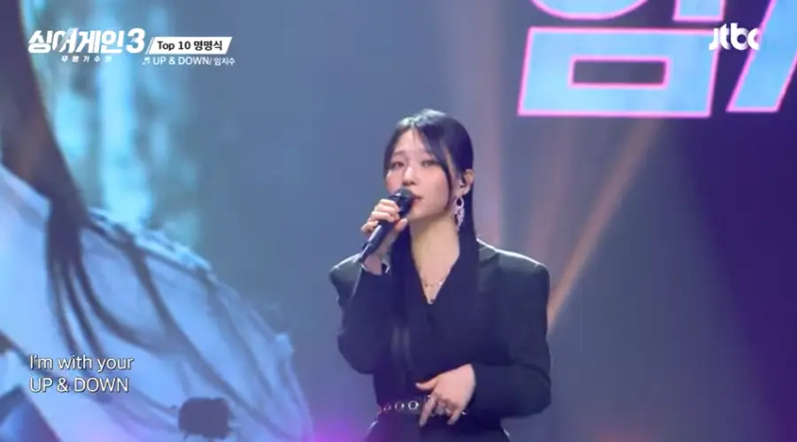 싱어게인3-
파란배경 검은 쟈켓 뒤로묶은 생머리에 긴 귀걸이를 하고 검은 마이크를 잡고 옆을 살짝보며 노래하는 27호