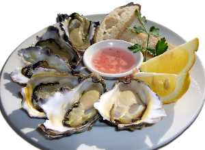 굴과 레몬이 한 접시에 담겨있다.
