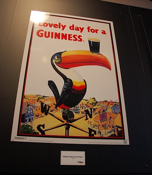 기네스 스토어하우스에 전시된 ‘Lovely day for a Guinness’ 빈티지 광고 포스터와 부리 위에 기네스 잔을 올린 큰부리새 그림