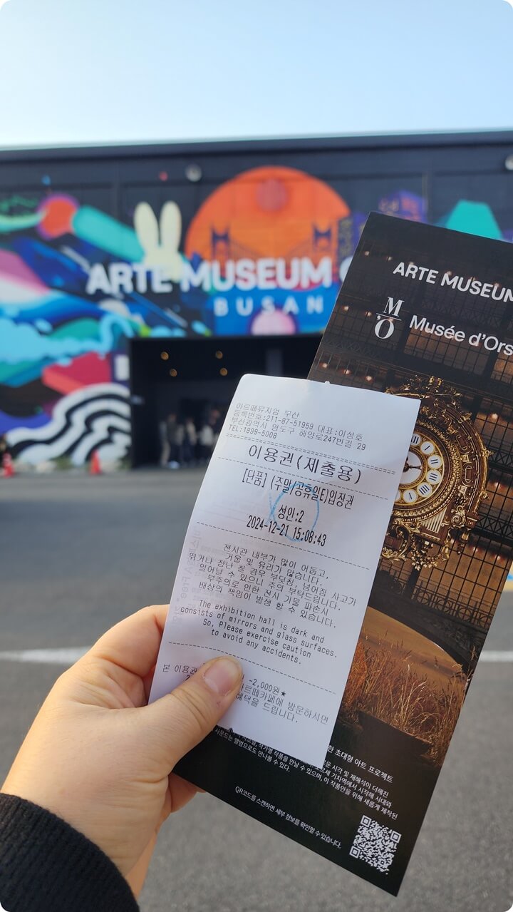 알록달록한 건물앞에서 찍은 입장권과 안내장