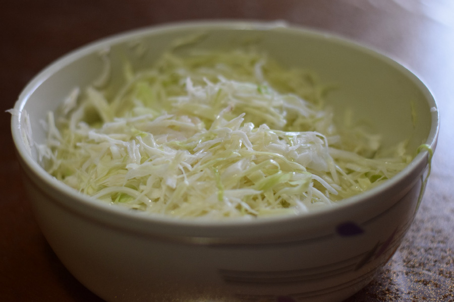 야생에서 채취를 한 양배추를 잘 세척한 후에 가늘게 채를 썬 것을 동그랗고 하얀 그릇에 가득 담아두고 찍은 사진