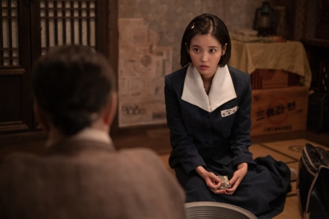 넷플릭스 드라마 폭싹 속았수다에서 교복을 입은 아이유가 진지한 표정으로 앉아 있는 장면