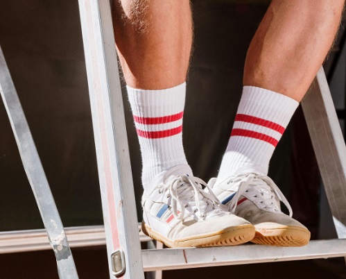 러닝 양말과 러닝화를 신고 앉아 있는 사람의 다리가 확대되어 있는 사진