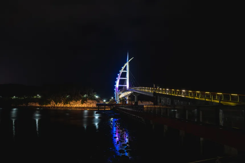 조명이 비추는 새연교 다리와 바다 위 반사된 불빛