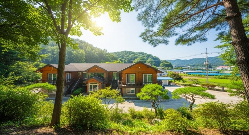 자연 속에 위치한 펜션 외관&amp;#44; 여름 나무 배경&amp;#44; 햇살 가득한 풍경