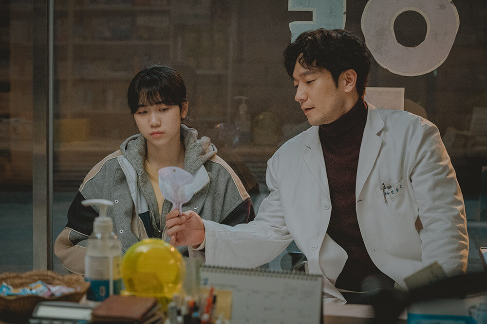 막대 사탕을 주며 인영에게 위로를 건네는 약사 아저씨