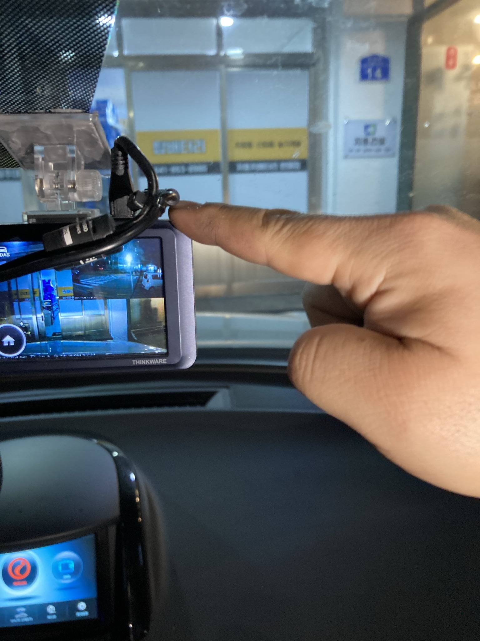 자동차 블랙박스 화면을 손가락으로 가리키며 주차모드 설정을 확인하는 모습