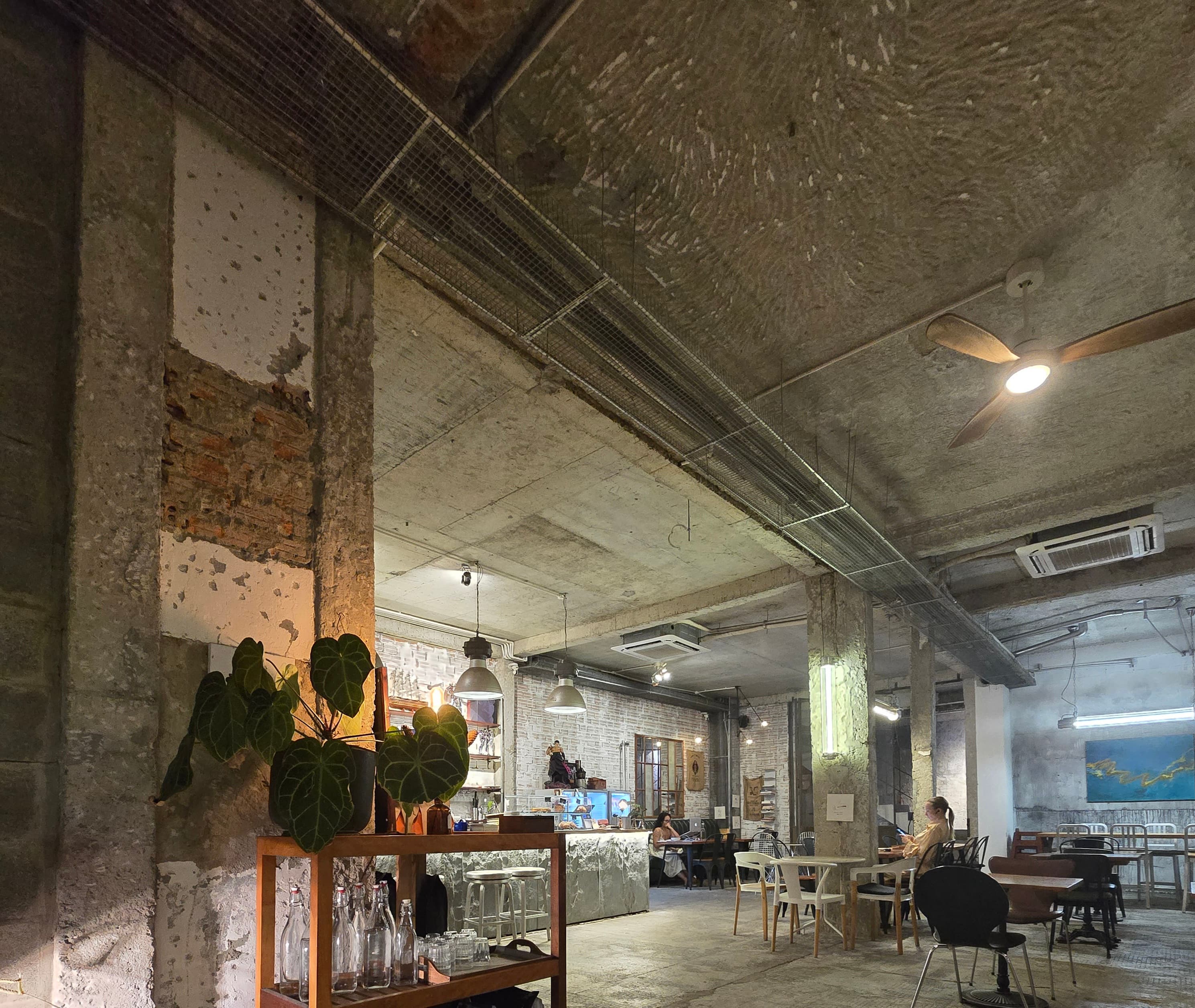 집중: 미래 계획을 위한 완벽한 타이밍-"거친 콘크리트와 따뜻한 조명이 어우러진, 베트남 감성 카페의 여유로운 오후. 이곳에서 내일을 천천히 그려본다."