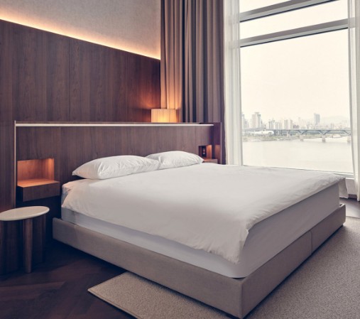 가운데 침대를 중심으로 창밖 멀리 대교가 보인다
천정간접조명이 멋진 이미지