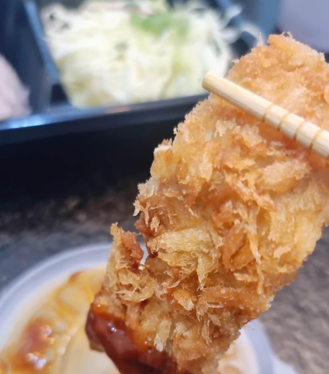 왕돈까스 젓가락으로 한개 소스에 찍어먹는 모습
