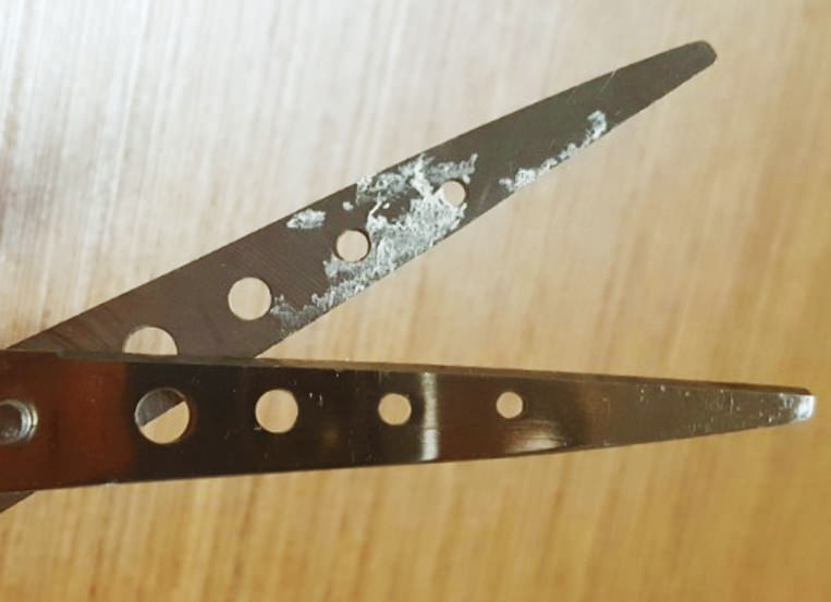 가위에 끈끈이가 붙어있는 모습