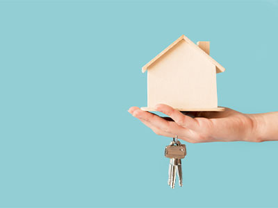 집 모형과 함께 키를 들고 있는 손 이미지