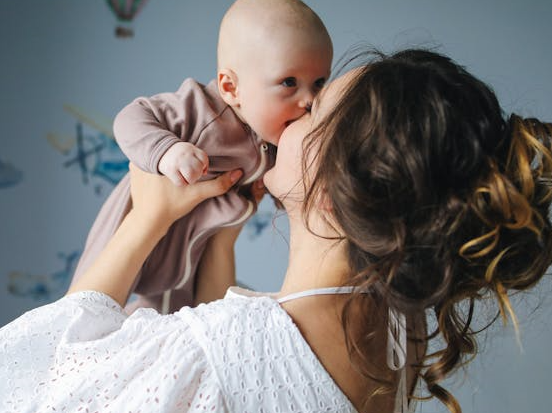 국민행복카드 바우처, 어디서 써야 하는지, 사용처 잘 알고 계시나요? - 신생아를 들어올리고 있는 엄마의 모습