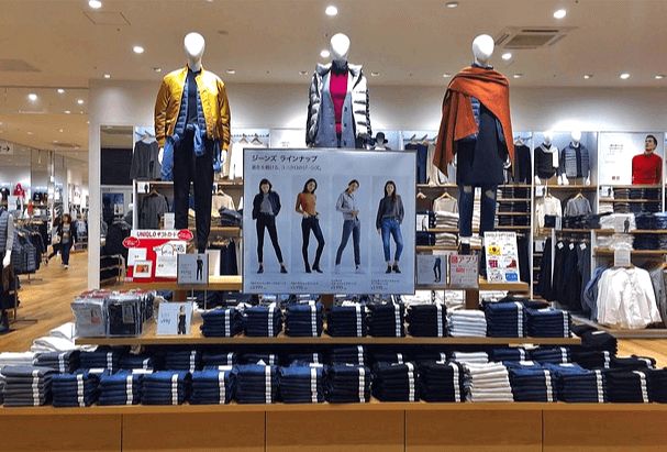 유니클로 의류 매장이다. 청바지와 옷들이 진열됐고 마네킹 3개가 가을 옷을 입고 서 있다.