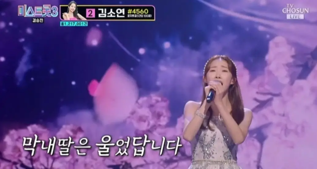 미스트롯3- 보라색 배경의 무대 앞 흰드레스를 입고 두손으로 마이크를 잡은채 노해하는 정서주