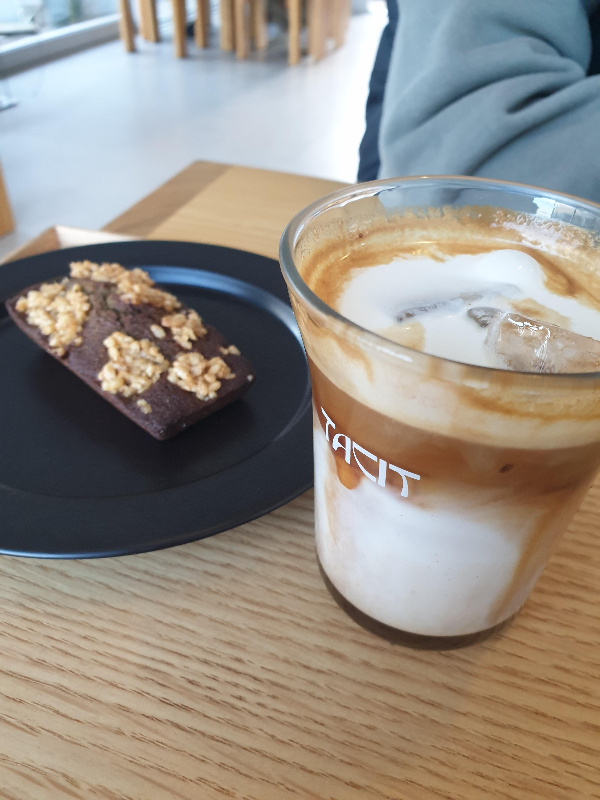 휘낭시에와 플랫화이트(태시트 라테)가 테이블 위에 올려져 있다.