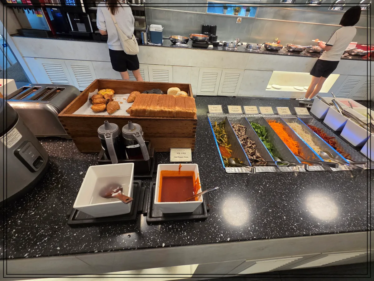 식빵과-크루아상-토스트기-옆에-김치-당근-콩나물-버섯-고추장-등-비빔밥-재료가-줄지어-놓여-있음