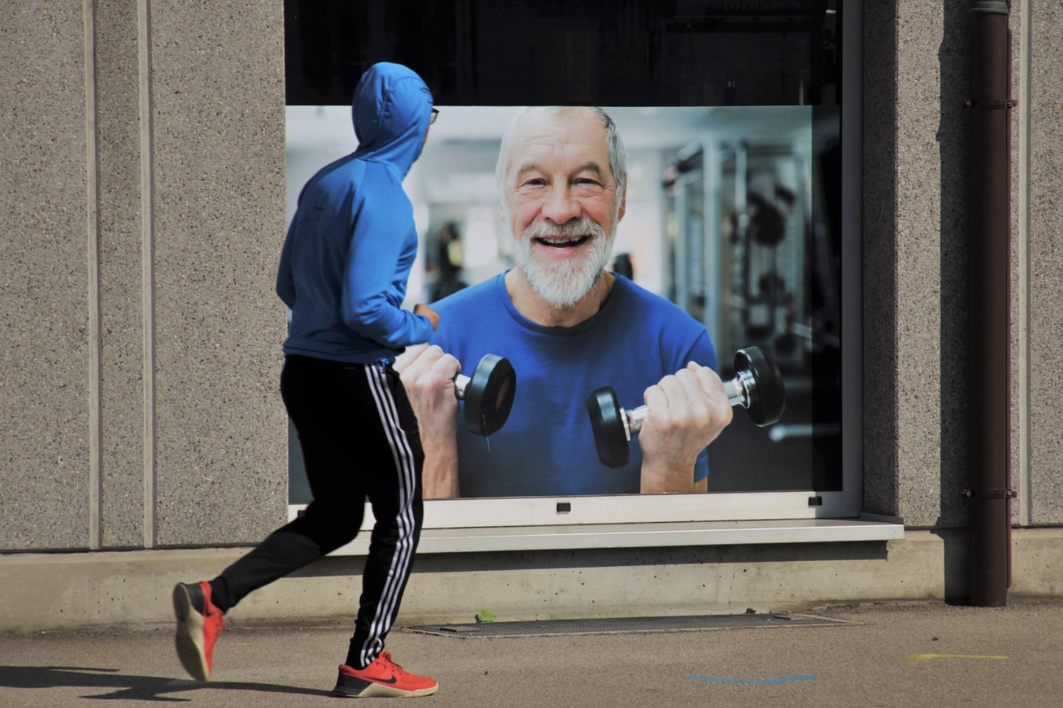 거리에서 조깅하는 사람과 규칙적인 운동을 상징하는 노년 남성의 근력 운동 광고 이미지