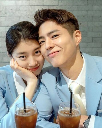 박보검과-수지가-하늘색-자켓을-입고-아메리카를-마시며-미소를-짓고있는-모습
