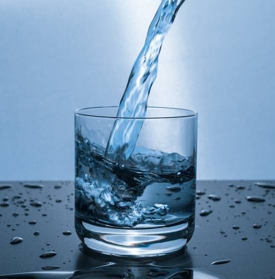 투명컵에 물을 반정도 따르고 있다.