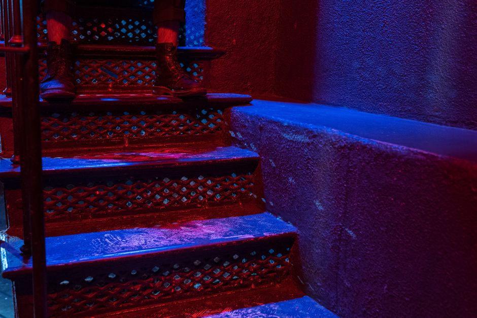 Colorful stairs at night with footwear, creating a moody nightlife vibe.