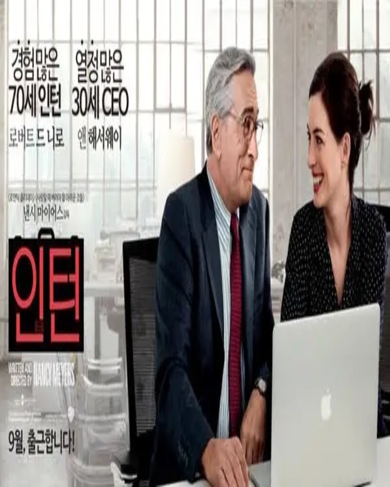 영화 인턴 한국 공식 포스터, 70세 인턴 로버트 드 니로와 30세 CEO 앤 해서웨이가 사무실에서 노트북을 보며 웃고 있는 모습