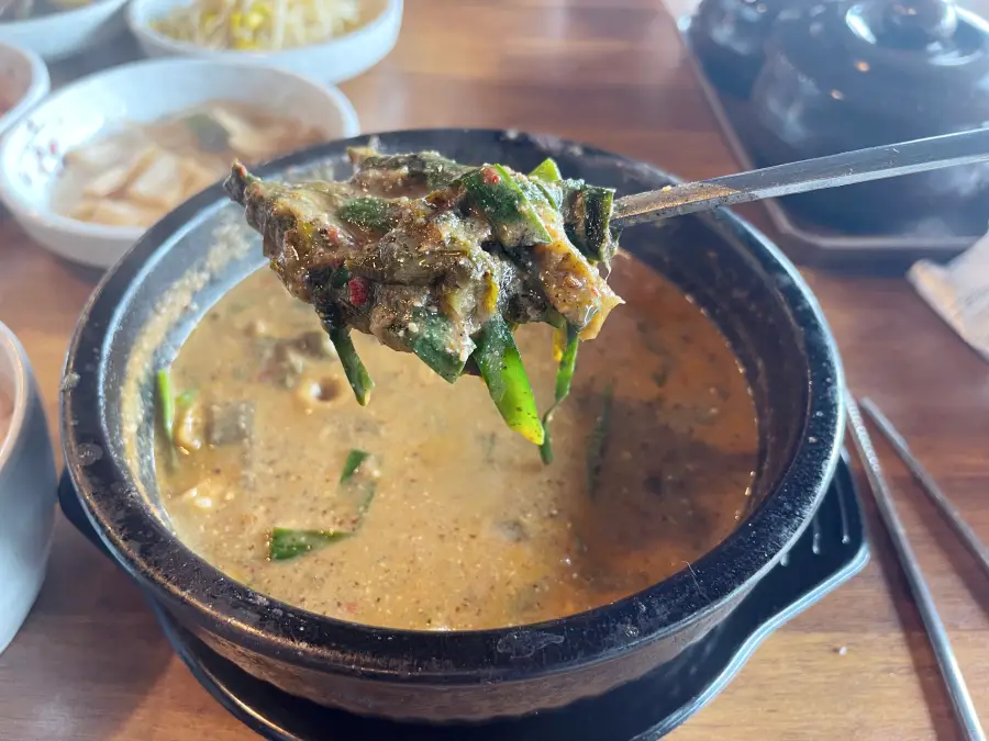 부추와 우거지가 같이 들어가 있는 추어탕의 모습 뚝배기의 담겨 있다