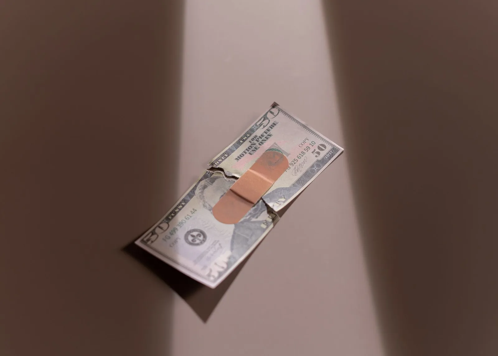 밴드가 붙은 50달러 지폐는 재정 회복과 수리를 상징합니다.