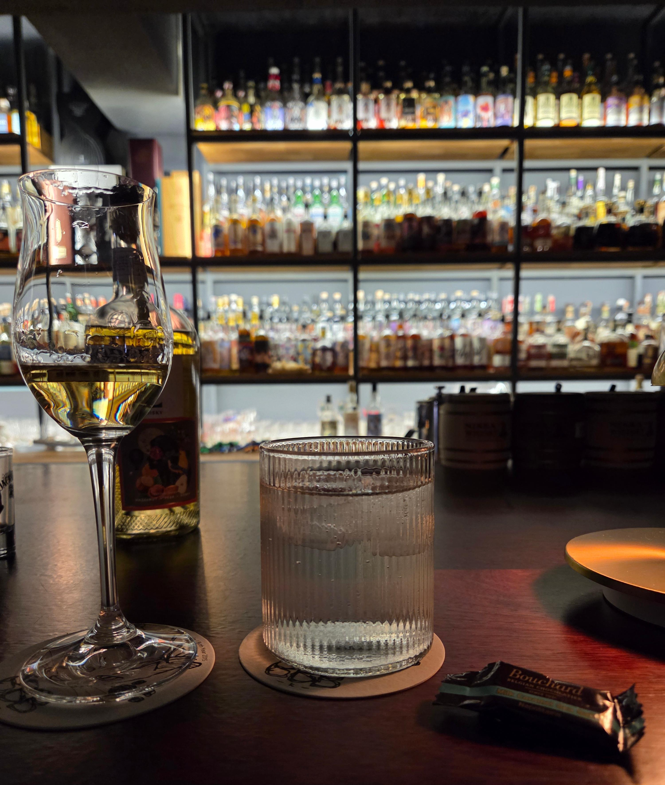 바밤 카운터 위에 놓인 노블 레벨(Noble Rebel) 위스키 잔과 병