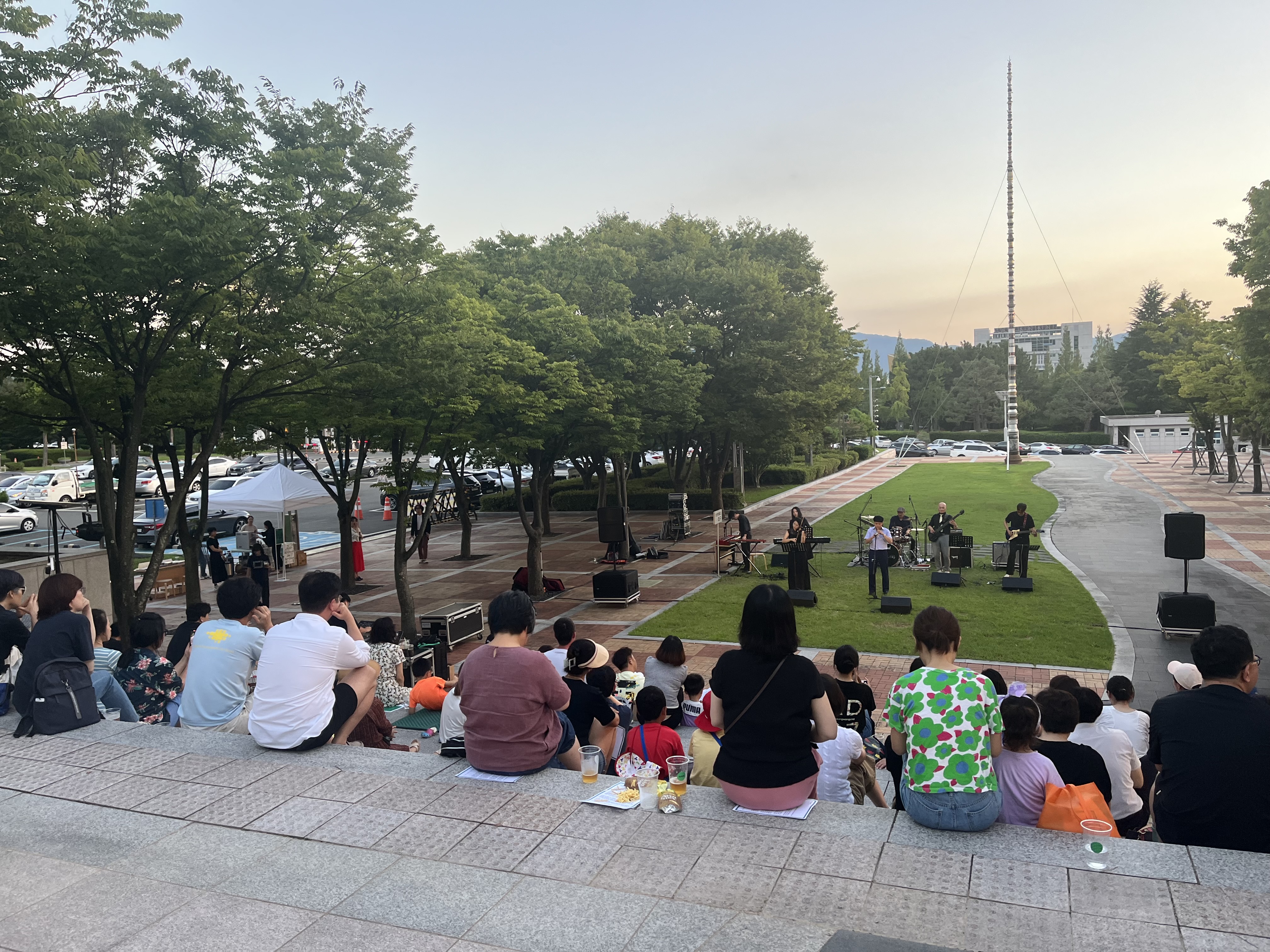 경남도립미술관 야외광장에 사람들이 모인 모습을 찍은 사진입니다.