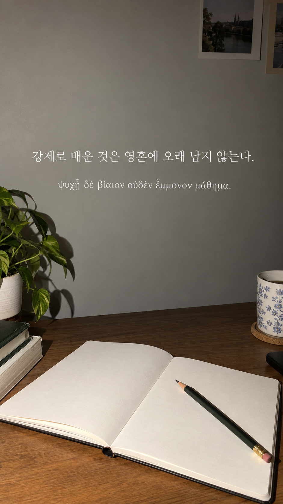 플라톤 명언 2 강제로 배운 것은 영혼에 오래 남지 않는다. 빈 공책과 연필이 놓인 책상 배경의 한글·그리스어 세로 이미지
