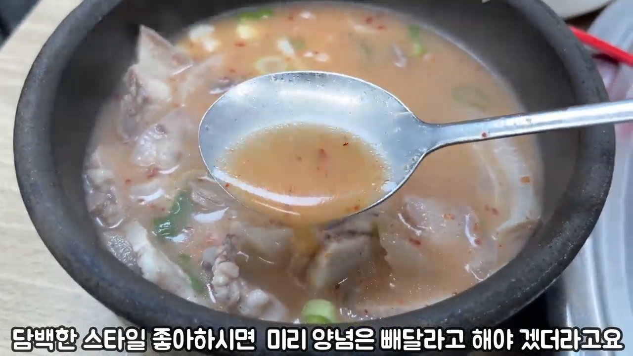 돼지국밥 뚝배기에서 국물을 뜬 모습