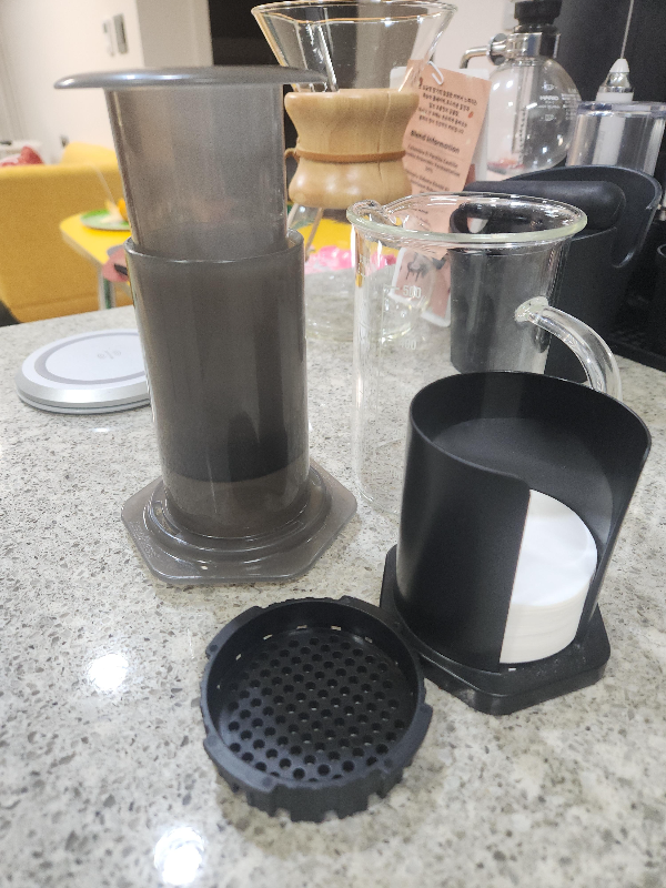 에어로프레스가 테이블 위에 올려져 있다. 에어로프레스와 함께 서버 그리고 케멕스도 보인다.