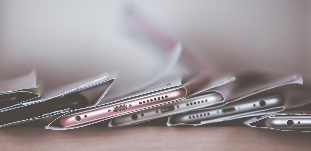 여러 대의 스마트폰이 테이블 위에 겹쳐져 놓인 모습