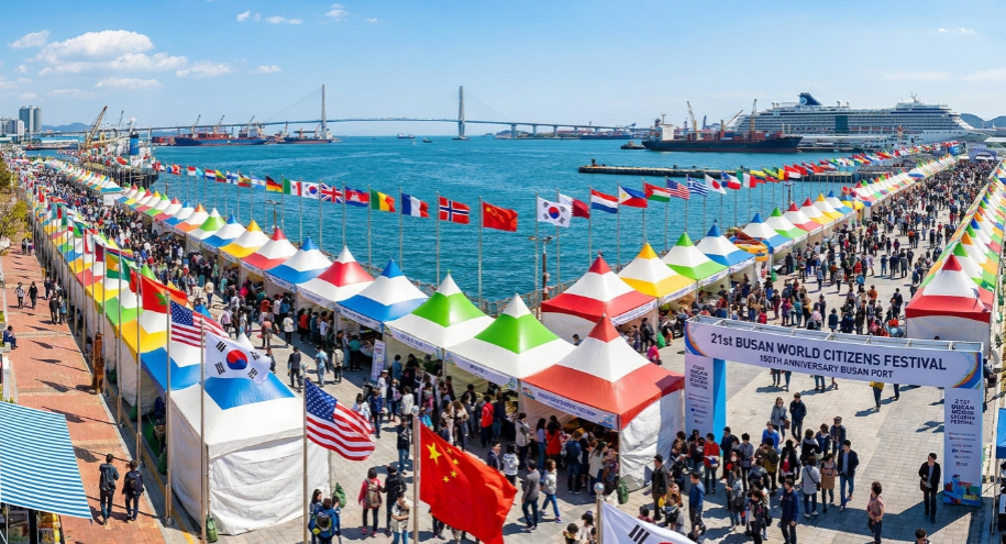 푸른 부산항 바다를 배경으로 세계 각국의 국기가 바람에 날리고 화려한 축제 부스들이 늘어선 풍경