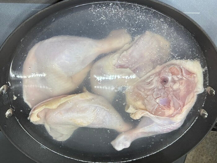 끓는 물에 데치고 있는 닭다리