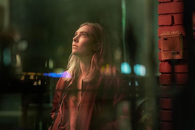 넷플릭스 영화 "Night Always Comes"의 스틸컷 : 밤거리 배경 속에 주인공 여성이 고개를 들어 위를 바라보는 장면