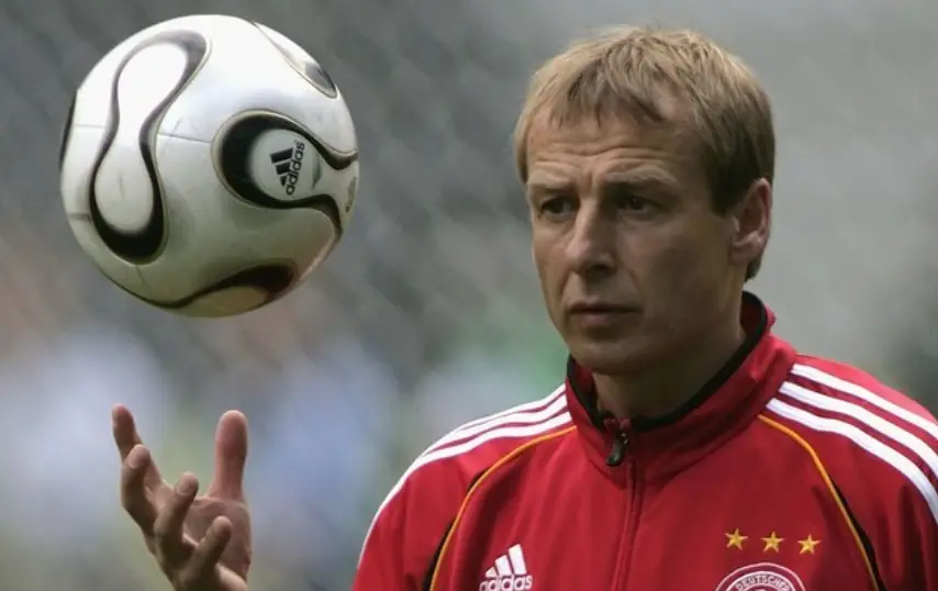 클린스만-붉은 츄리닝을 입고 오른손으로 공을 위로 던지는 클린스만 감독