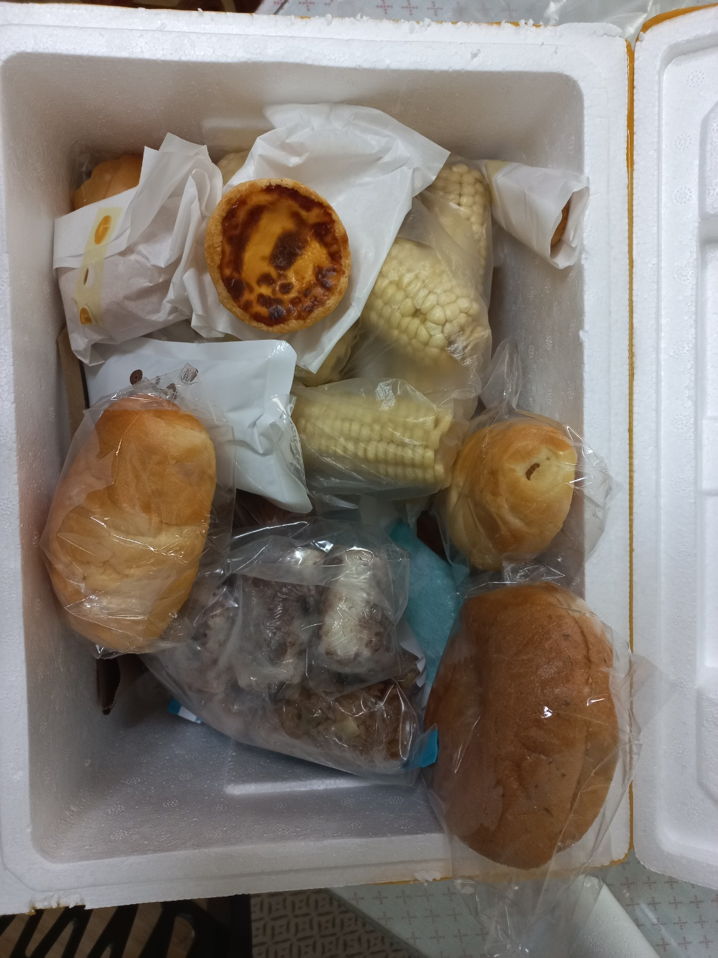 택배 상자안에 넣어 있는 소금빵&#44; 옥수수&#44; 떡 사진