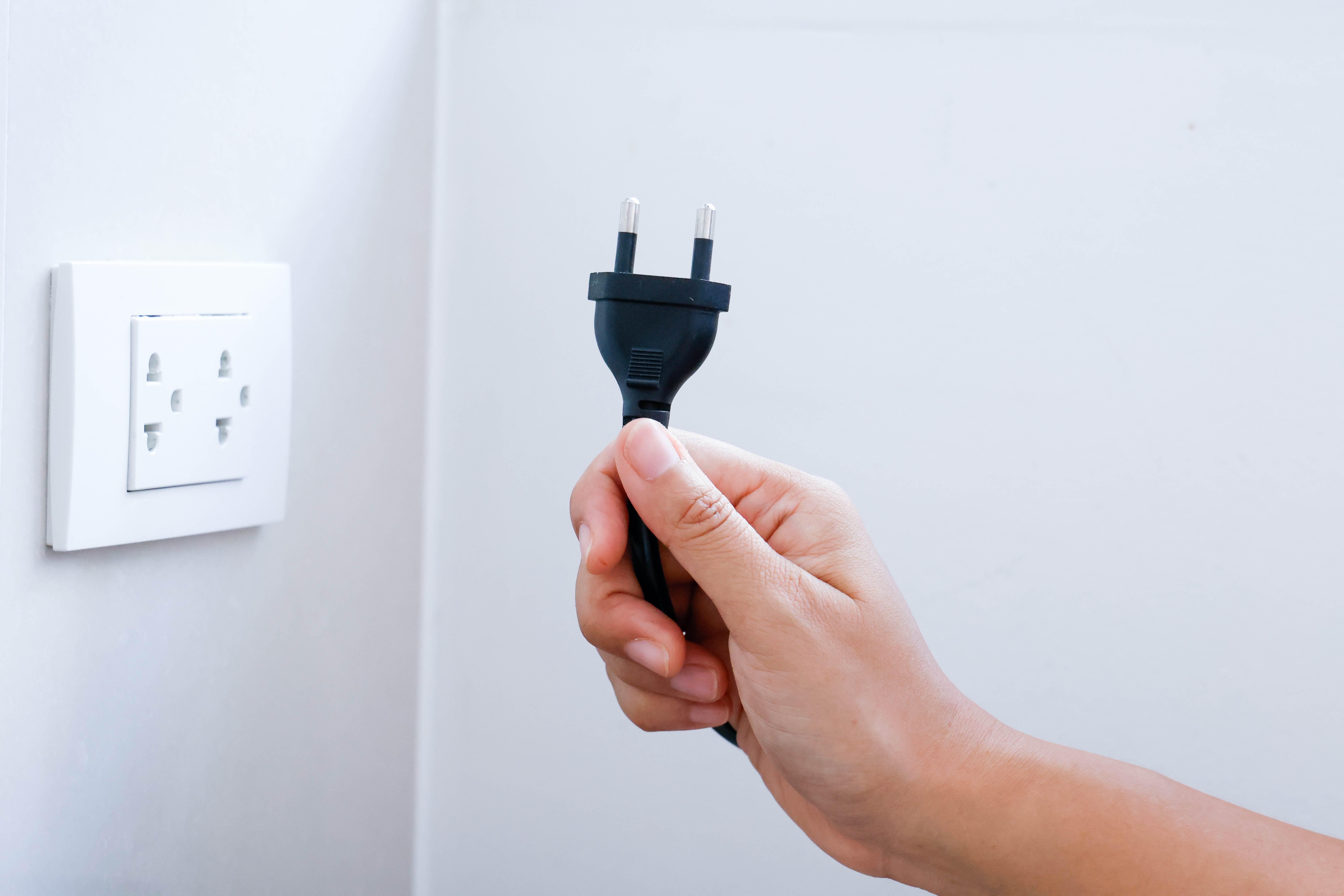 전기 절약을 위해 콘센트에서 플러그를 뽑는 모습