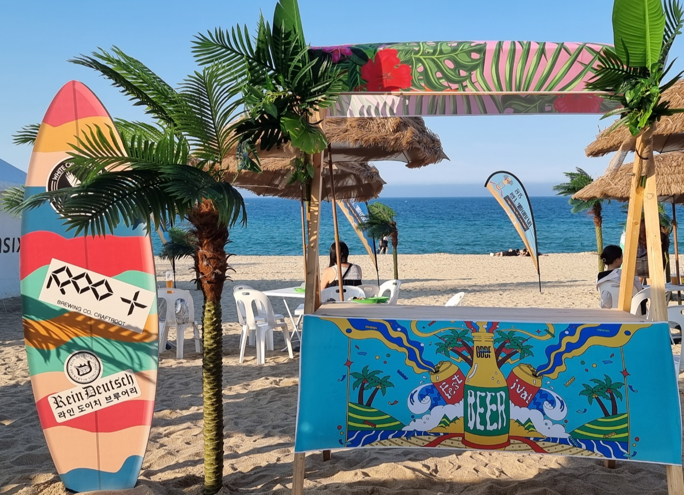 '와이키키 인 강릉'이라는 주제에 맞게 인조 야자수나무, 비치 파라솔과 의자 및 테이블, 써핑보드, 조형물 등으로 경포 해변을 꾸민 모습이다.