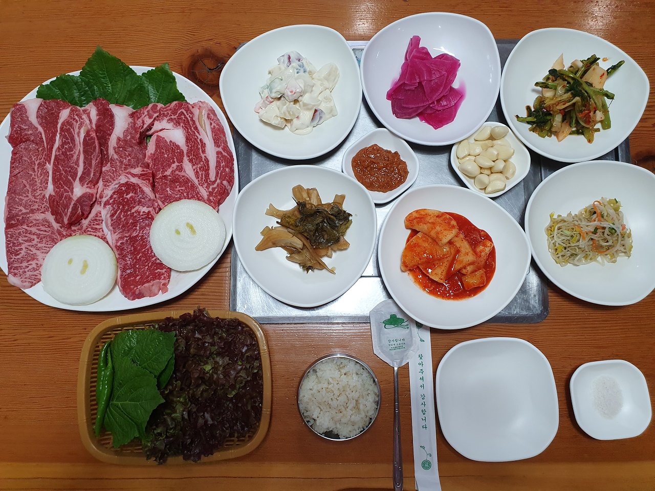 소고기 모듬구이랑 각종 반찬이 상에 놓인 사진