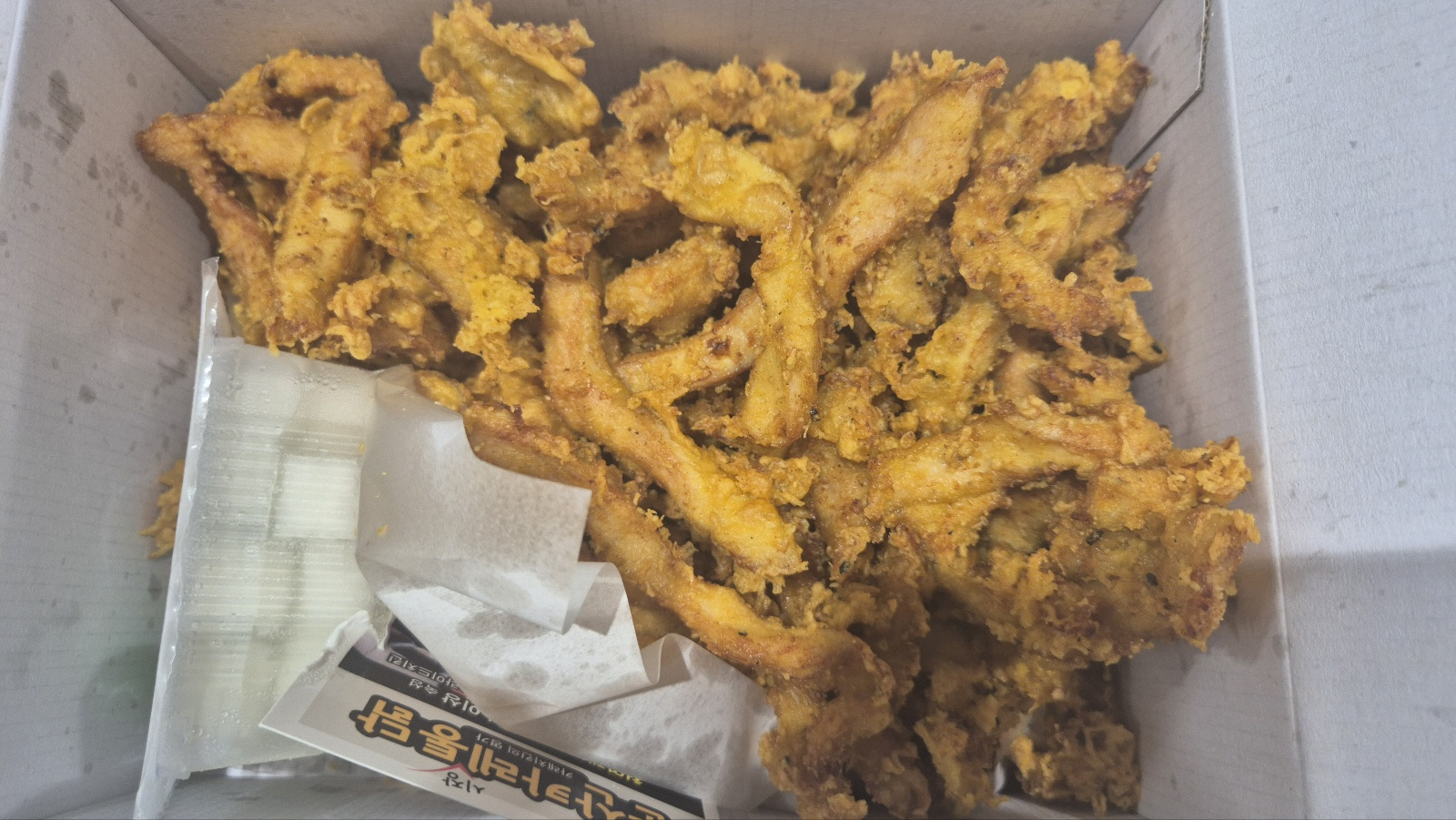 통닭 내용물 소금과 광고전단지 그리고 단무지가 보인다.