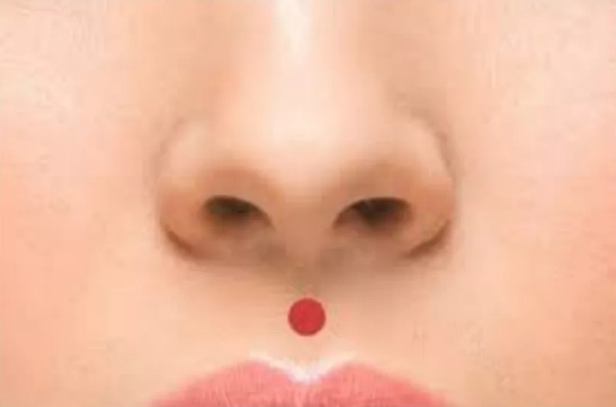 인체의 365혈 중에서 코와 윗입술 사이에 있는 인중혈의 위치를 빨간 점으로 표시를 한 이미지 사진