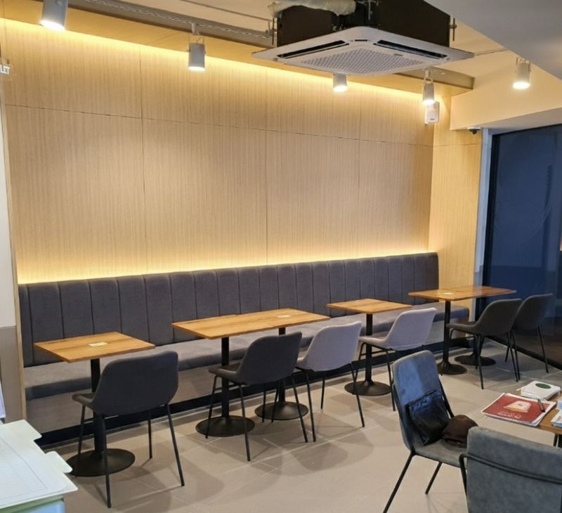 전구색 간접 조명이 은은하게 비추는 따뜻한 분위기의 카페 내부 사진